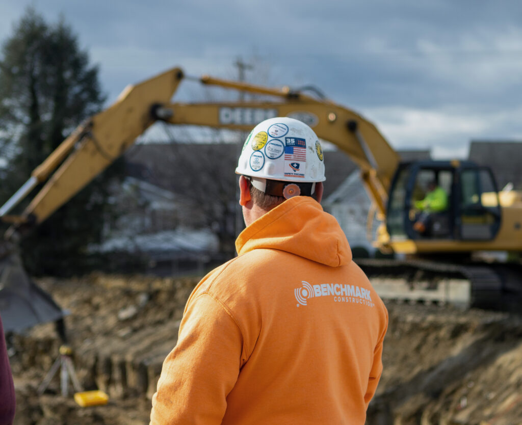 View of the back of Benchmark team member in a construction helmet