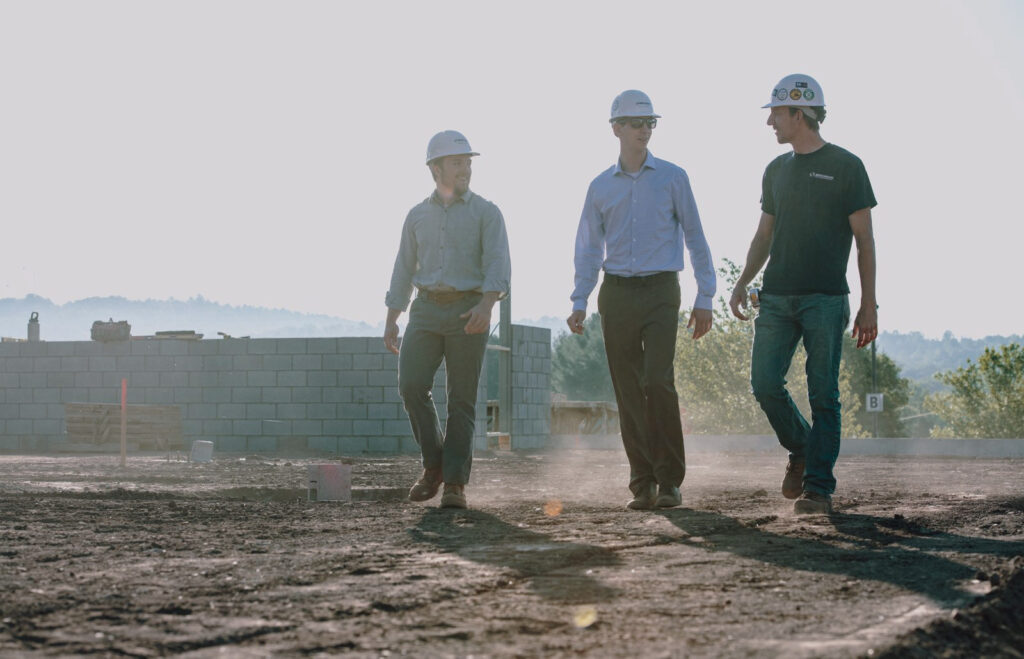 Three Benchmark team members walk through an in progress job site
