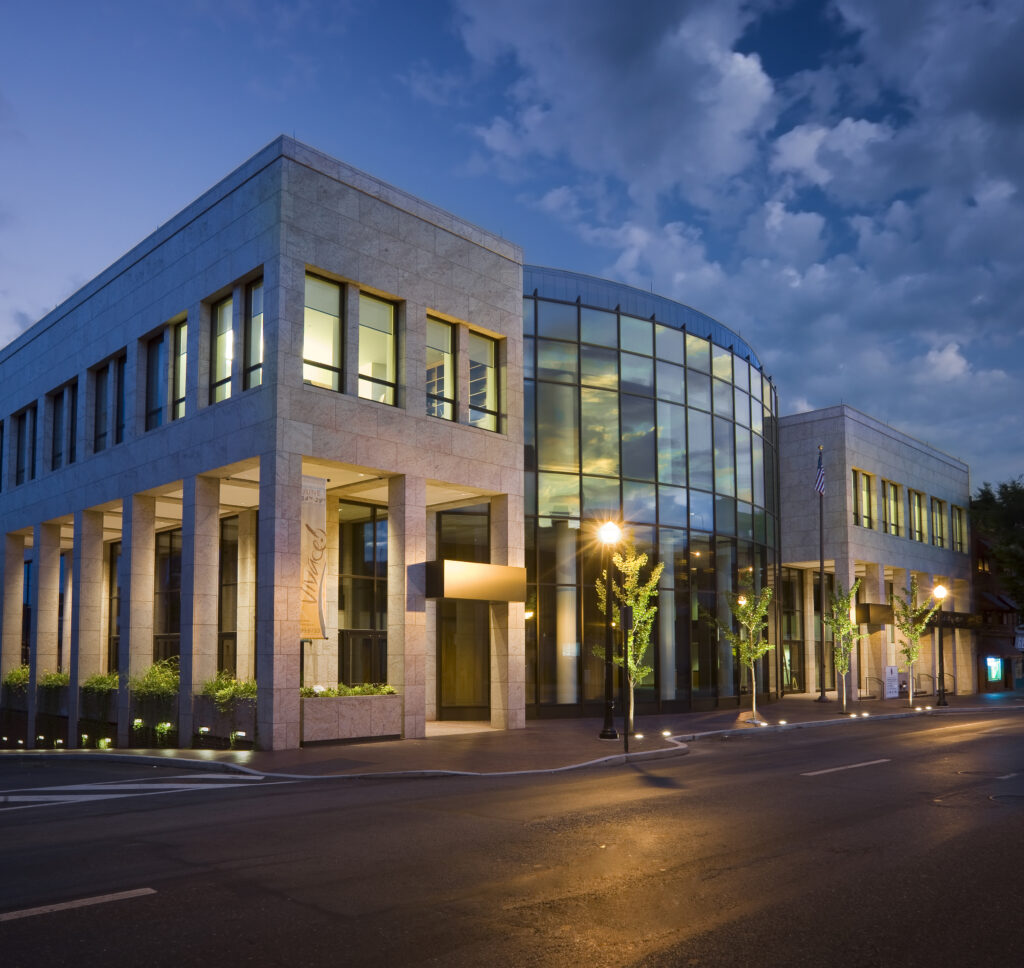 Exterior night view of education buildings made of different materials including glass