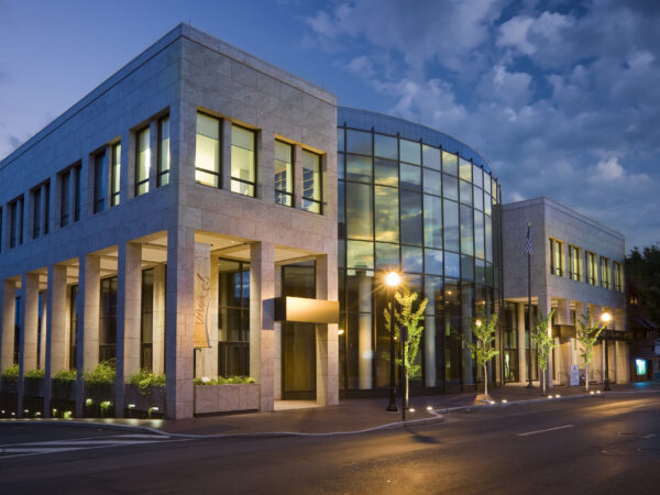 Exterior night view of education buildings made of different materials including glass