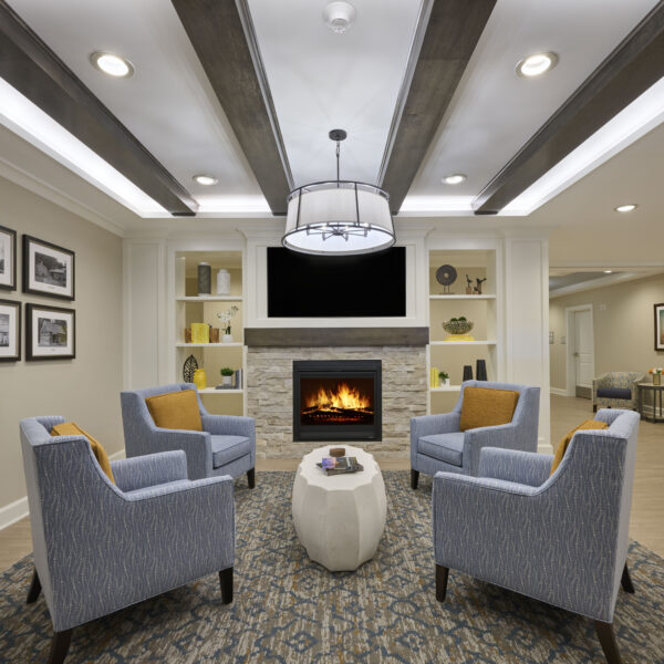 Interior of a common space with four chairs in front of a fireplace